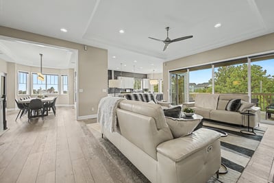 Contemporary open-concept living area featuring large windows and seamless outdoor access, perfect for entertaining.