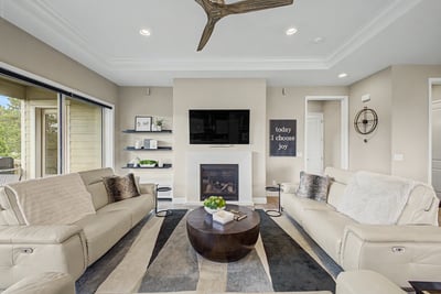Bright and inviting living room featuring modern furnishings, a cozy fireplace, and large windows for natural light.