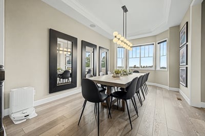 Bright dining area features modern decor with large windows, perfect for gatherings and enjoying natural light.