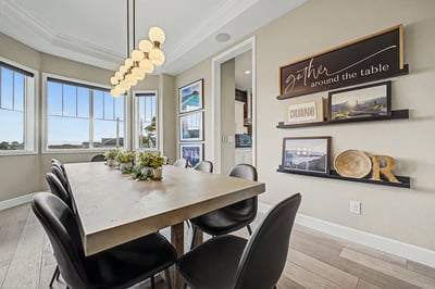 Modern dining area featuring large windows, a sleek table, and captivating artwork for a welcoming atmosphere.