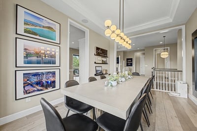 Bright dining area featuring a modern table, gallery artwork, and open flow to the living space.
