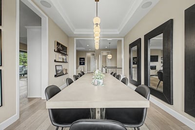 Discover a spacious dining area perfect for gatherings, featuring modern lighting and large mirrors for added depth.