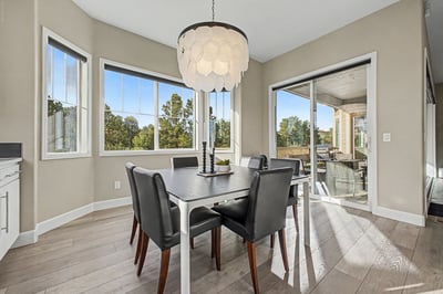 Bright dining area with large windows, offering scenic views and seamless access to outdoor living space.