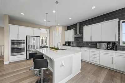 This modern kitchen features sleek cabinetry, stainless steel appliances, and an inviting island perfect for gatherings.