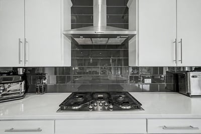 Modern kitchen featuring sleek cabinetry, stainless steel appliances, and a contemporary backsplash for a sophisticated cooking experience.
