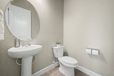 Modern bathroom featuring a sleek round mirror and minimalist design, enhancing spatial efficiency and functionality.