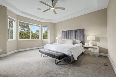 Bright and spacious master suite featuring large windows, modern fixtures, and a comfortable seating area.