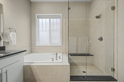 Modern bathroom featuring a spacious walk-in shower and soaking tub with natural light from the window.