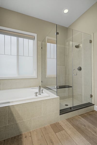 Bright and modern bathroom featuring a spacious walk-in shower and a luxurious soaking tub.