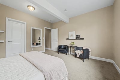 Bright and spacious bedroom featuring modern touches, ample natural light, and functional seating areas.