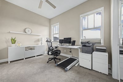 Bright and functional home office with modern furnishings and ample natural light, ideal for productivity.
