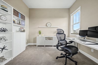 Bright home office featuring modern furnishings and built-in shelving, ideal for productivity and comfort.