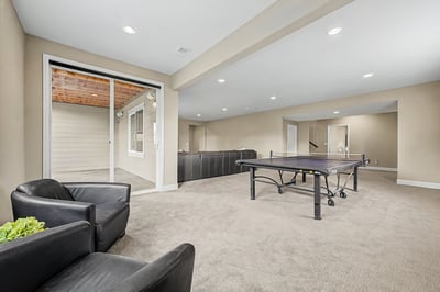 Spacious recreational area featuring a ping pong table and patio access for entertaining guests.