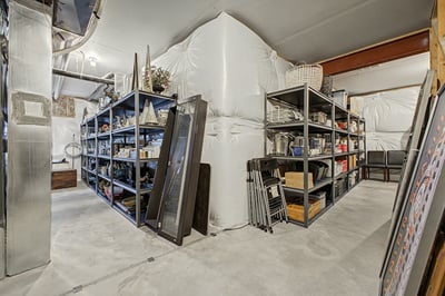 Spacious basement with ample shelving, ideal for storage or workshop space, designed for easy organization.