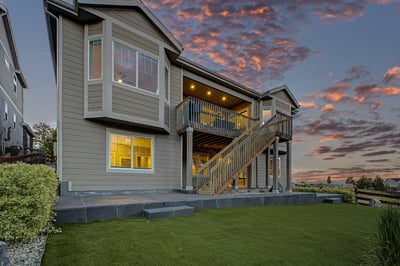This modern home features spacious outdoor decks and expansive windows, perfect for enjoying stunning sunset views.