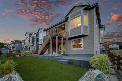 Modern home featuring a spacious backyard, expansive deck, and stunning sunset views in a vibrant neighborhood.
