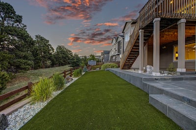 Contemporary backyard retreat features lush landscaping and stunning sunset views, perfect for outdoor gatherings and relaxation.