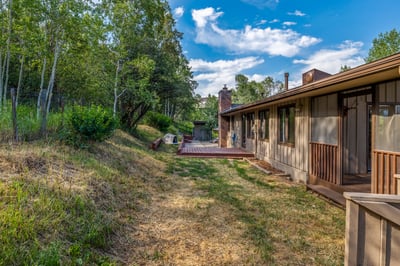 This home features ample outdoor space surrounded by natural greenery, perfect for gatherings and relaxation.