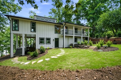 Modern home with spacious outdoor areas, abundant greenery, and a thoughtful design near the water.