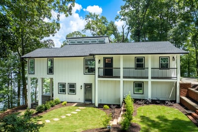 Modern lakeside home featuring expansive outdoor spaces, large windows, and direct access to tranquil waters.