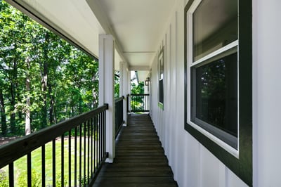 Bright and inviting covered walkway surrounded by lush greenery, offering a unique transition to outdoor living.