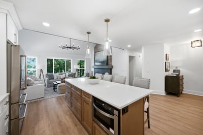 Modern kitchen featuring a spacious island, large windows, and an open layout connecting to the living area.
