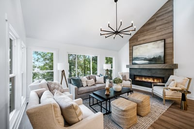 Bright and airy living room featuring large windows, a modern fireplace, and inviting seating arrangements.