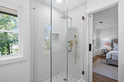 Modern glass shower with sleek finishes, featuring abundant natural light and peaceful views from nearby windows.