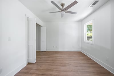 Bright, open room featuring modern finishes, ample natural light, and a convenient ceiling fan.