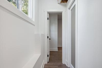 Bright and inviting hallway with natural light, leading to additional living spaces and modern features.