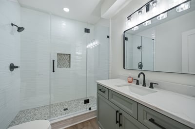 Modern bathroom featuring a spacious walk-in shower, sleek fixtures, and a polished marble countertop.