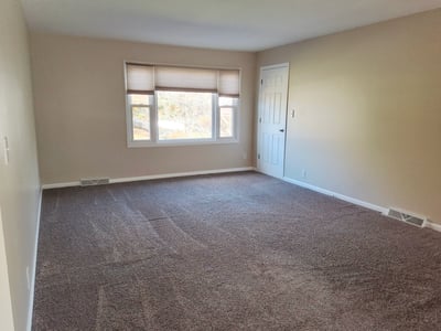Apartment Living Room w/ storage closet, cordless shades & new carpet 2021 - empty view Fall 2025 before tenants