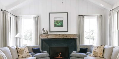 Experience contemporary charm in this inviting living room, featuring high ceilings, a cozy fireplace, and stylish decor.