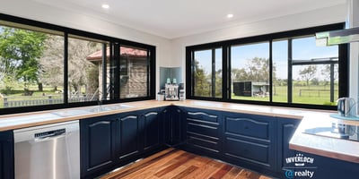Modern kitchen with panoramic windows, featuring sleek cabinetry and scenic views of the surrounding landscape.