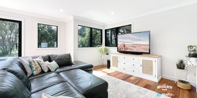 Spacious living area features large windows, modern furnishings, and ample natural light for a welcoming atmosphere.