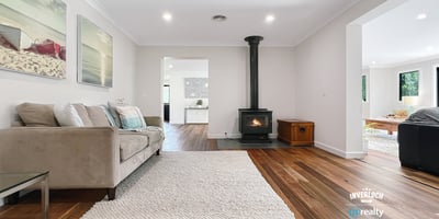 Spacious living area featuring natural light, modern decor, and a cozy fireplace, perfect for gatherings.