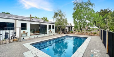 This contemporary home features a spacious outdoor area with a pristine pool and landscaped surroundings.
