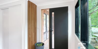 Contemporary entryway featuring a sleek front door and natural light enhancing the warm wooden floors.