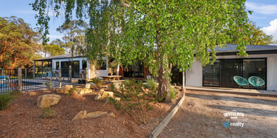 Contemporary home surrounded by lush landscaping, featuring spacious outdoor areas and modern design elements.