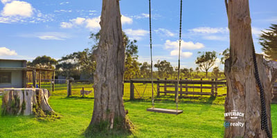 Expansive property featuring a relaxing swing, surrounded by lush greenery and open countryside views.