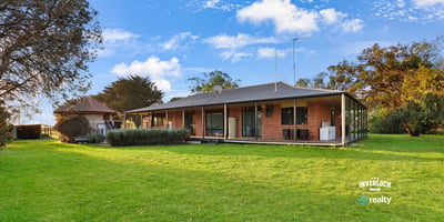 Spacious home set on expansive grounds, featuring large windows and a seamless indoor-outdoor living experience.
