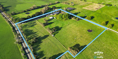 Spacious rural property featuring open fields, ponds, and mature trees, offering endless possibilities for development.