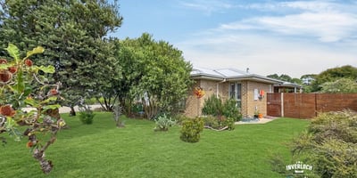 This inviting home features a spacious yard, surrounded by lush greenery and abundant natural light.
