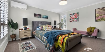 Spacious bedroom featuring modern décor, ample natural light, and cozy accents for a welcoming atmosphere.