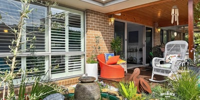 Discover a welcoming entryway featuring lush landscaping and inviting outdoor seating for relaxation and enjoyment.