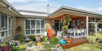 Inviting outdoor space featuring lush gardens and a spacious entertaining area, perfect for gatherings or relaxation.