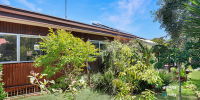 This inviting home features vibrant greenery and spacious outdoor areas, perfect for relaxation and entertainment.