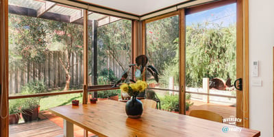 Bright indoor-outdoor living space featuring abundant natural light and a peaceful garden view.