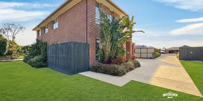 Spacious two-story home with ample outdoor space, lush landscaping, and convenient parking in a welcoming neighborhood.