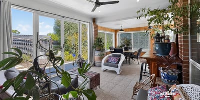 Bright and inviting sunroom with abundant greenery, perfect for relaxation and entertaining year-round.